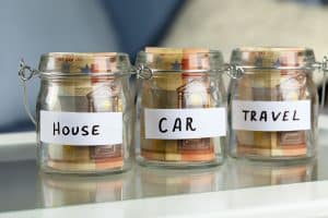 Glass jar with banknotes showcasing IVA living expenses allowances