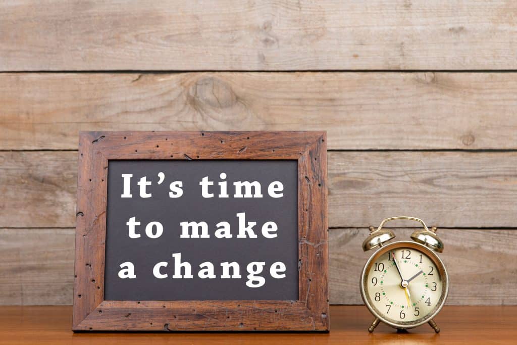Alarm clock and blackboard with text "It's time to make a change" showcasing cancel IVA and go bankrupt