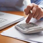 Find out what your monthly IVA payment will be Man Working Out Household Finances showcasing what your IVA payment will be