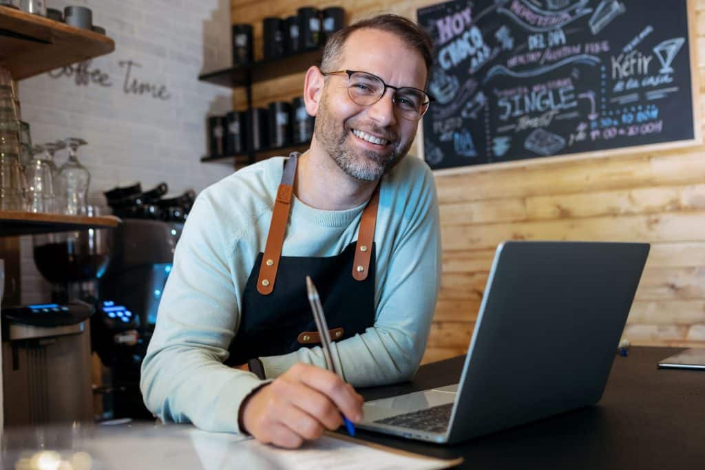 bakery owner working with laptop in a shop showcasing self employed IVA.