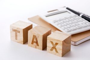 The word tax written on wooden boxes showcasing how tax debt is included in an IVA