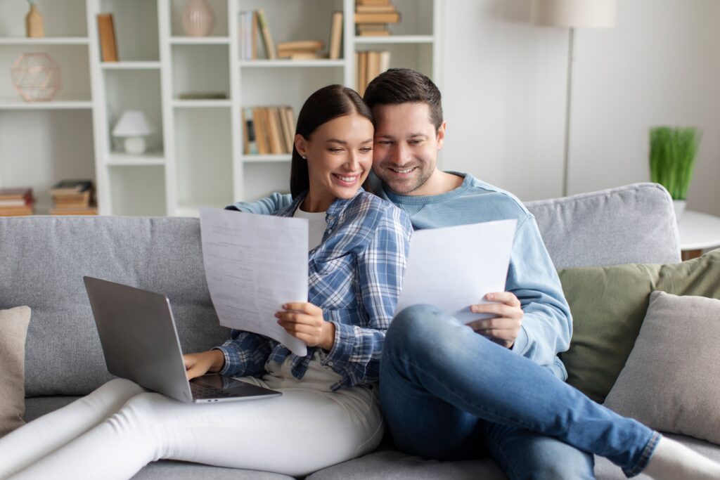 Happy young couple looking at bills to showcase starting a joint IVA