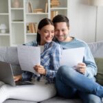 Can I do a joint IVA Happy young couple looking at bills to showcase starting a joint IVA