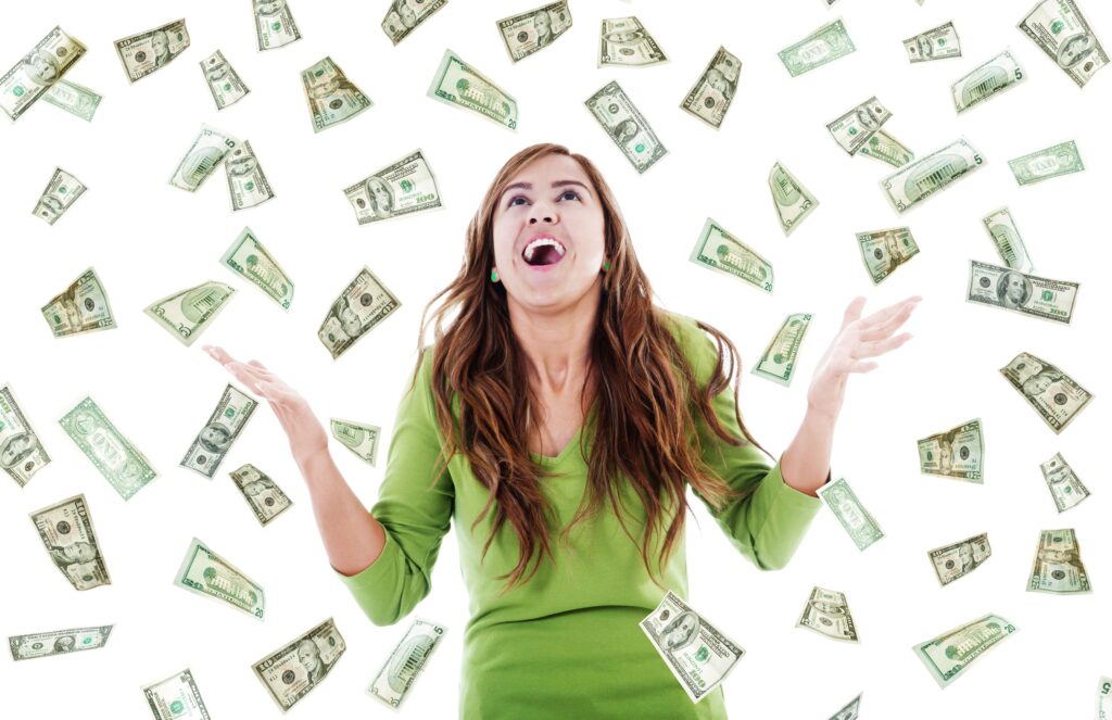 Happy woman trying to catch falling money showcasing what happens to a windfall in an IVA